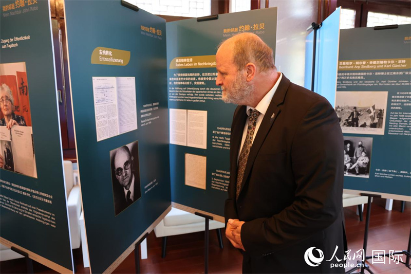 圖為賴因哈特在仔細觀看介紹拉貝生平的展板。人民網記者 劉仲華攝。